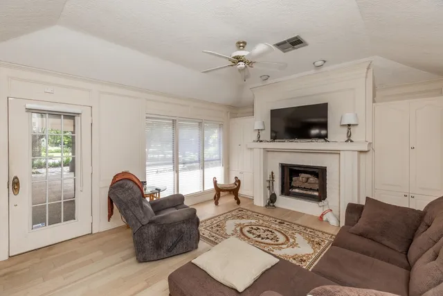 a living room with furniture a flat screen tv and a fireplace