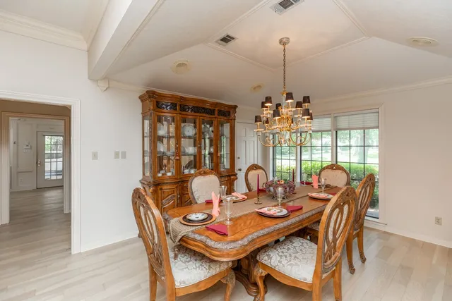 a dining room with furniture a chandelier and wooden floor