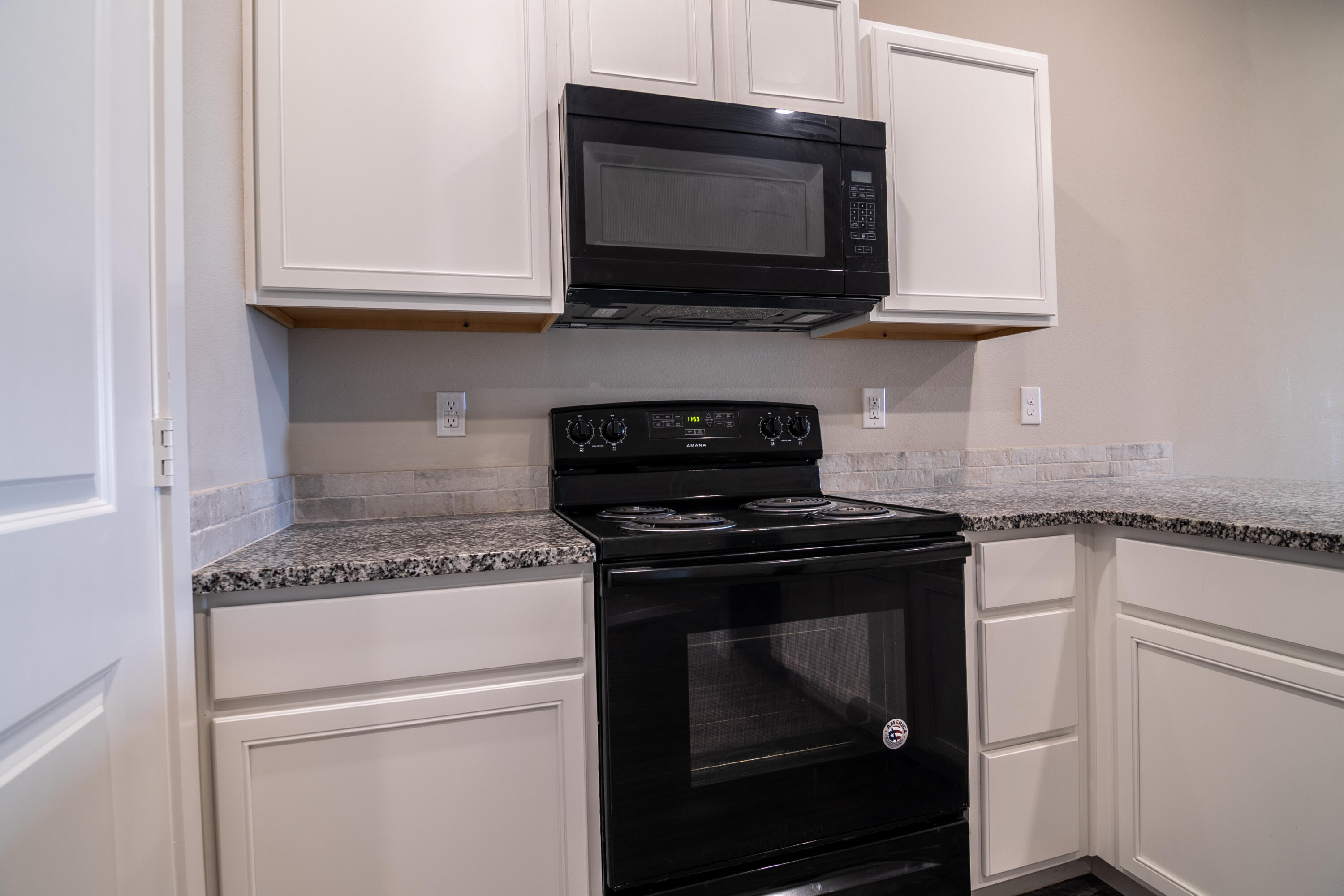 2118 Langford Avenue, Unit B Lubbock, TX 79407 - Photo 18 of 19 a kitchen with stainless steel appliances granite countertop white cabinets and a stove top oven