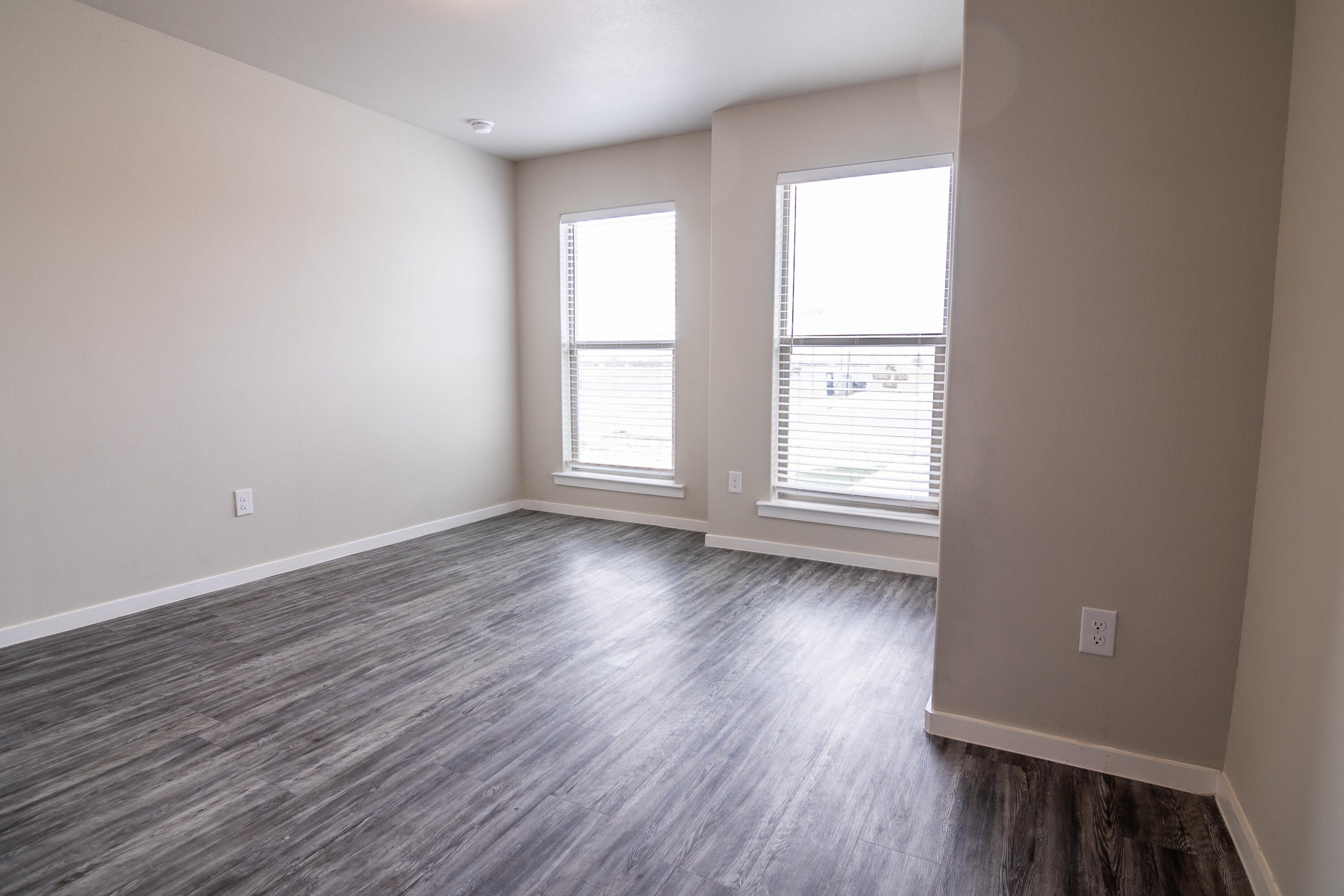 2118 Langford Avenue, Unit B Lubbock, TX 79407 - Photo 5 of 19 an empty room with wooden floor and windows