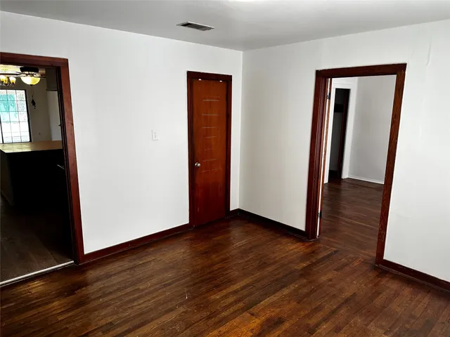 an empty room with wooden floor and closet