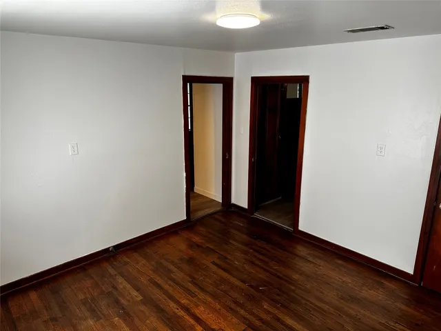 an empty room with wooden floor and closet