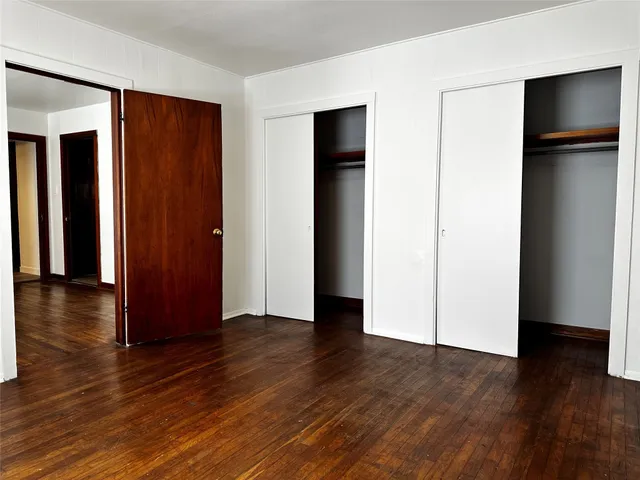 an empty room with wooden floor and closet