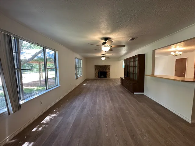 a view of a big room with wooden floor a chandelier