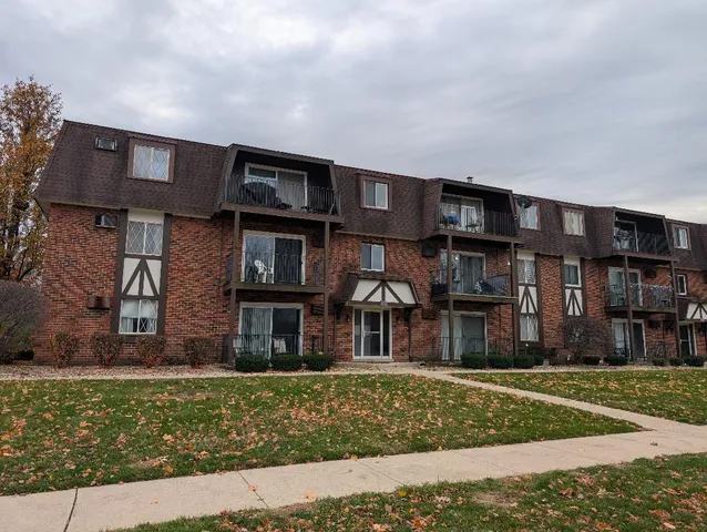 a front view of a residential apartment building with a yard