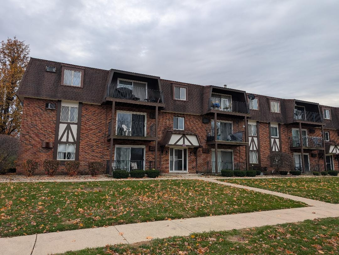 a front view of a residential apartment building with a yard