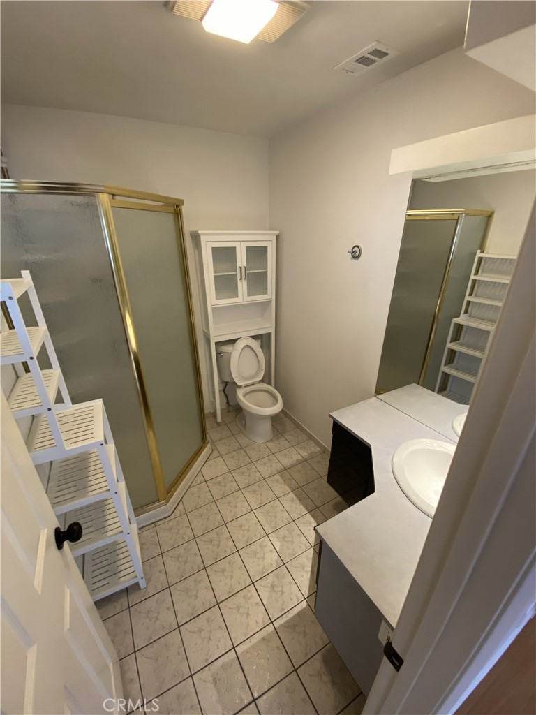 10535 Samoa Avenue Tujunga, CA 91042 - Photo 11 of 25 a bathroom with a sink a toilet a mirror and vanity