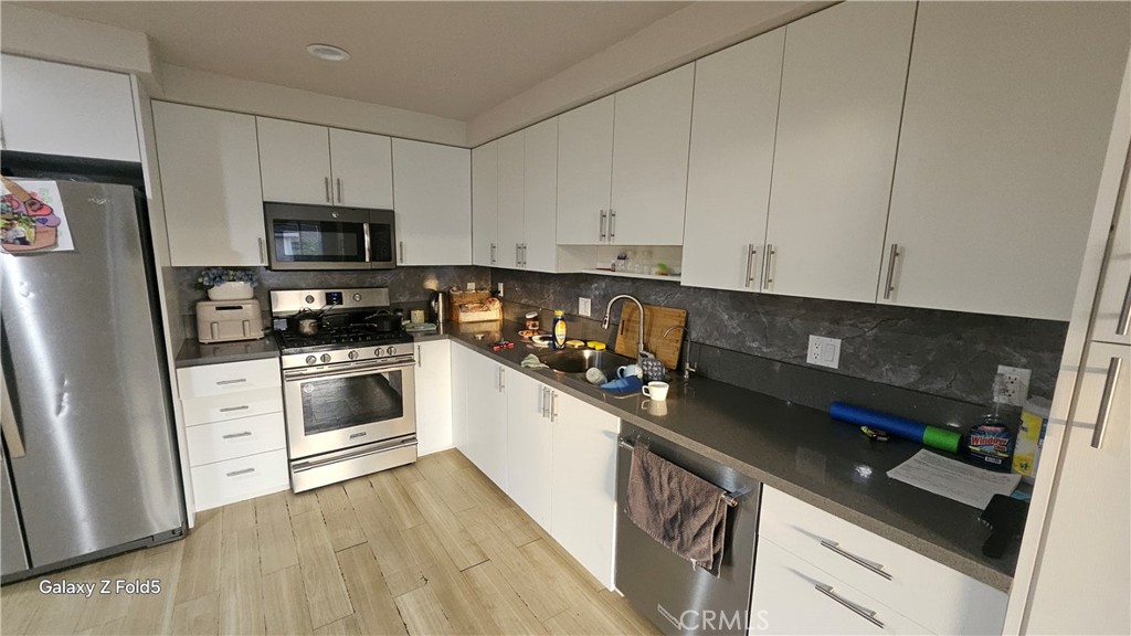 10535 Samoa Avenue Tujunga, CA 91042 - Photo 7 of 25 a kitchen with white cabinets and appliances