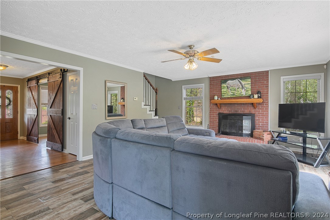 7833 Shuttle Road Fayetteville, NC 28311 - Photo 13 of 46 a living room with furniture a fireplace and a flat screen tv