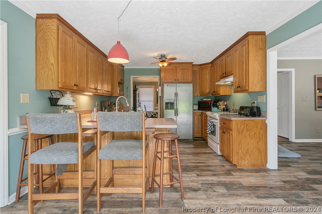 7833 Shuttle Road Fayetteville, NC 28311 - Photo 15 of 46 a dining room with a table chairs and a kitchen view