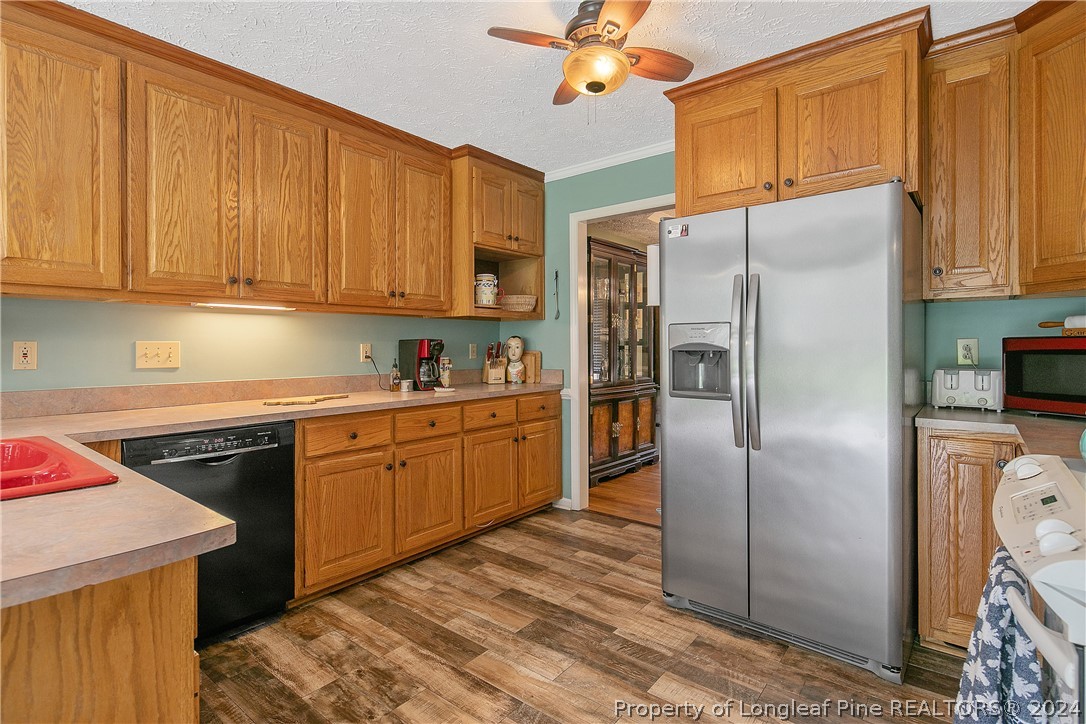 7833 Shuttle Road Fayetteville, NC 28311 - Photo 16 of 46 a kitchen with stainless steel appliances granite countertop a refrigerator a sink dishwasher a stove with wooden cabinets and floor