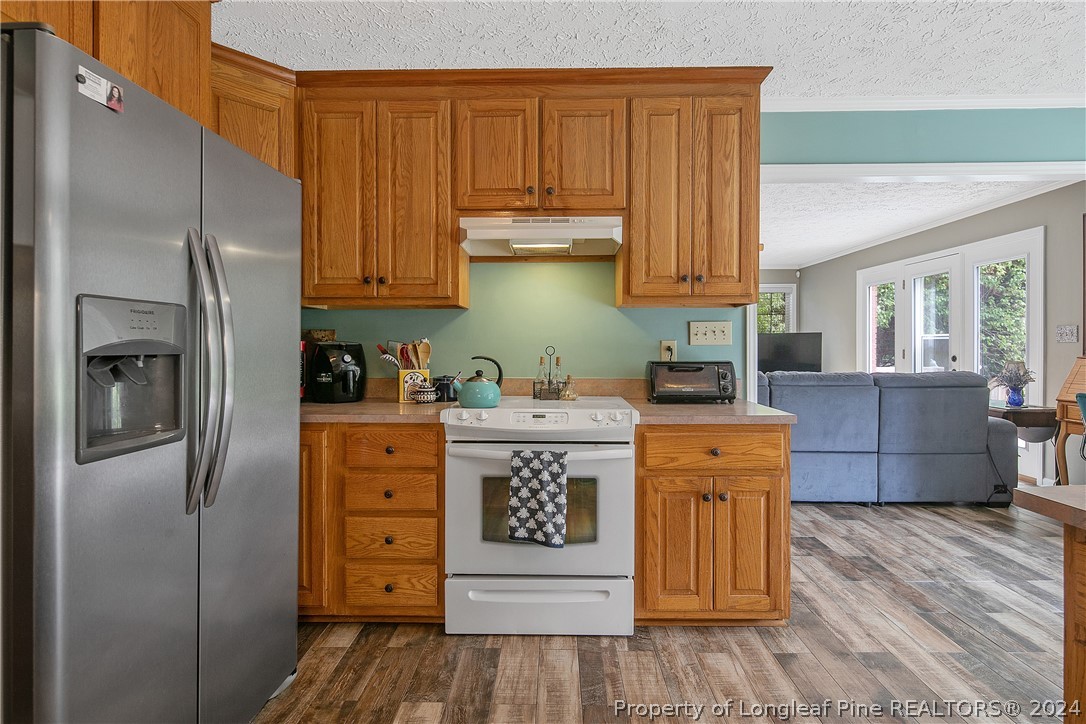 7833 Shuttle Road Fayetteville, NC 28311 - Photo 20 of 46 a kitchen with stainless steel appliances granite countertop a refrigerator a stove and a wooden cabinets