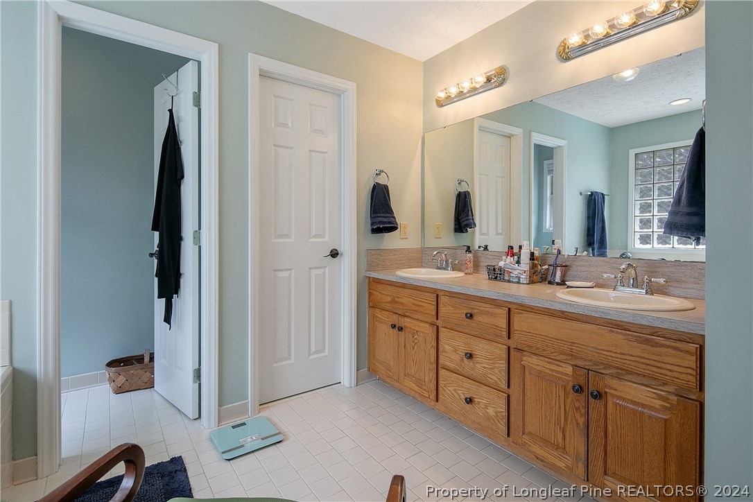 7833 Shuttle Road Fayetteville, NC 28311 - Photo 27 of 46 a spacious bathroom with double vanity and a mirror