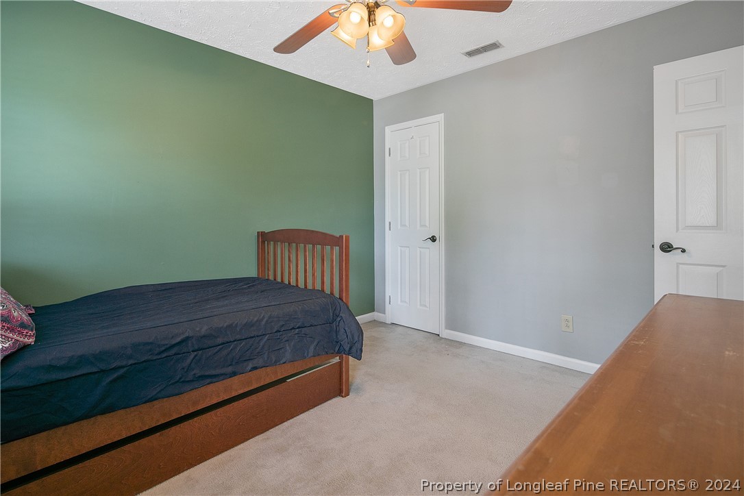 7833 Shuttle Road Fayetteville, NC 28311 - Photo 31 of 46 a room with a bed and a chandelier