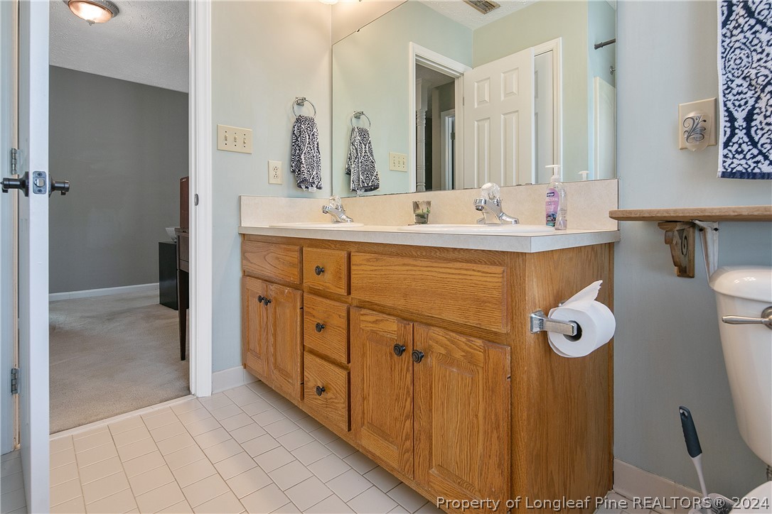 7833 Shuttle Road Fayetteville, NC 28311 - Photo 34 of 46 a bathroom with a double vanity sink mirror and toilet