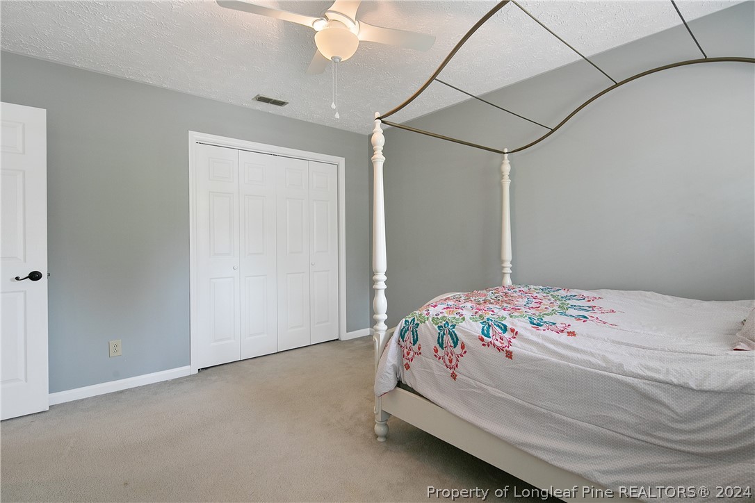 7833 Shuttle Road Fayetteville, NC 28311 - Photo 37 of 46 a bedroom with a bed and a chandelier