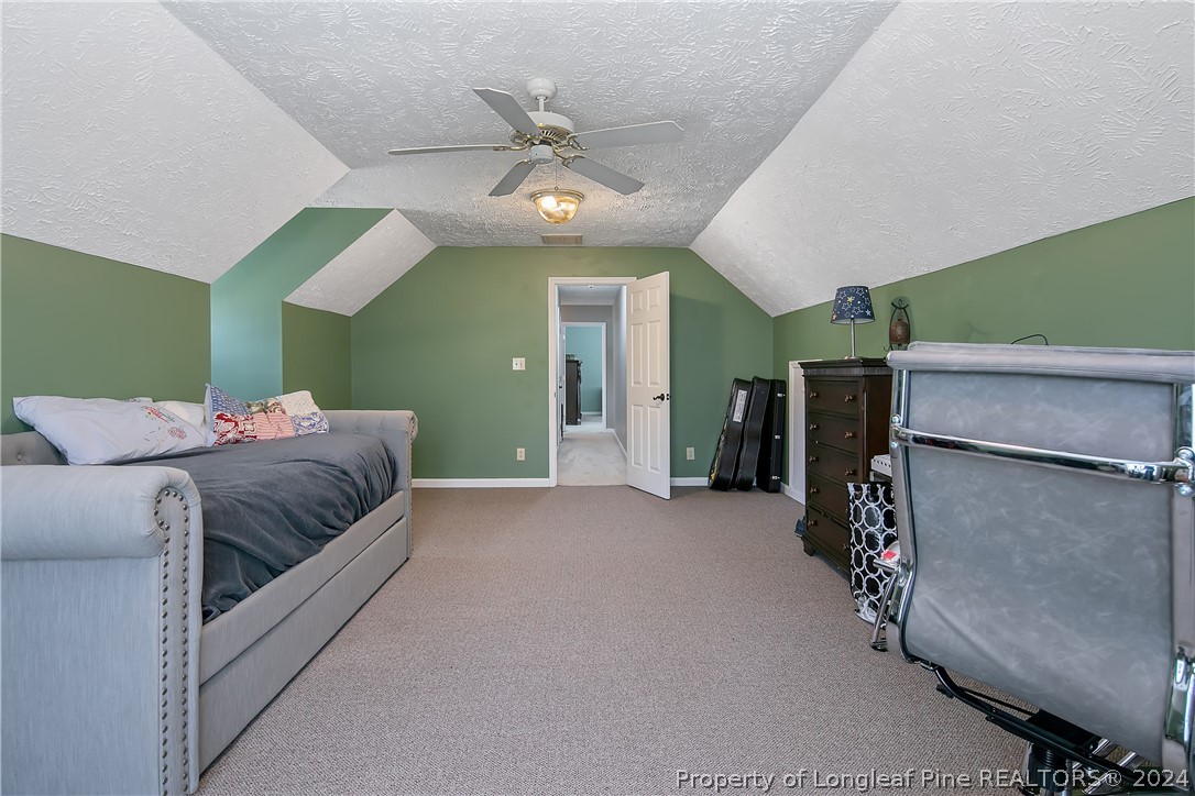 7833 Shuttle Road Fayetteville, NC 28311 - Photo 39 of 46 a spacious bedroom with a bed and a chandelier