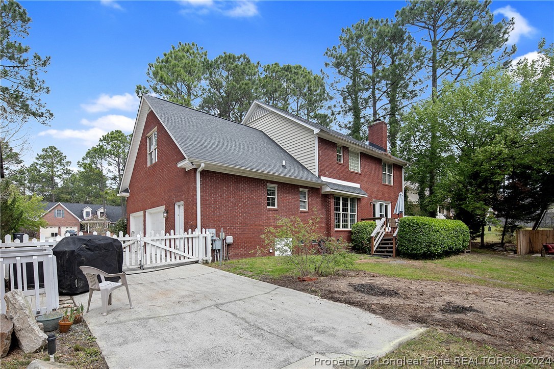 7833 Shuttle Road Fayetteville, NC 28311 - Photo 42 of 46 a brick house with a yard plants and large tree