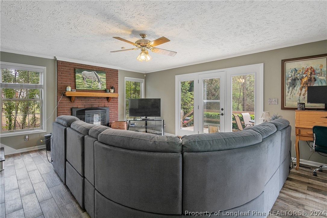 7833 Shuttle Road Fayetteville, NC 28311 - Photo 10 of 46 a living room with furniture a fireplace and a flat screen tv