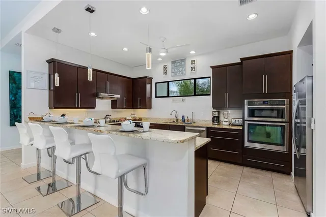 a kitchen with stainless steel appliances kitchen island granite countertop a stove and cabinets