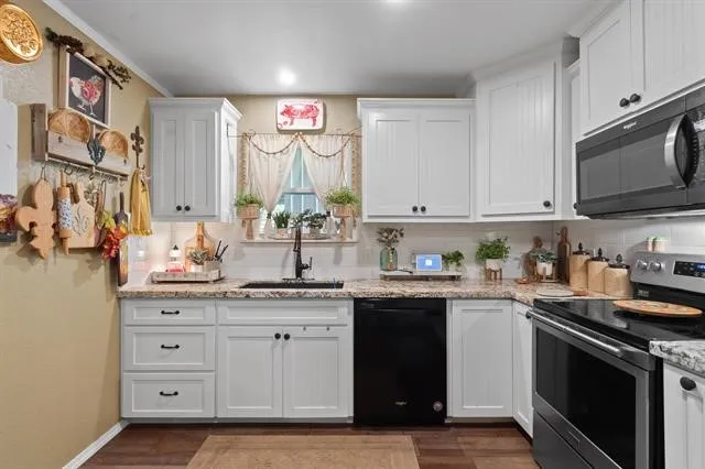 a kitchen with stainless steel appliances granite countertop a stove a sink and a microwave