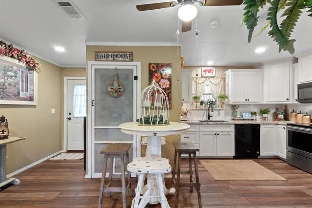 a kitchen with stainless steel appliances kitchen island granite countertop a sink and cabinets