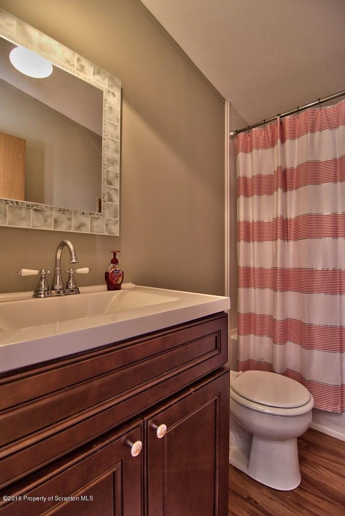 2131 Madisonville Road Moscow, PA 18444 - Photo 34 of 49 a bathroom with a sink a toilet a mirror and shower curtain