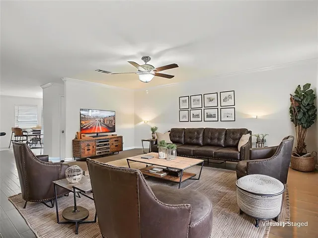 a living room with furniture a ceiling fan and a window
