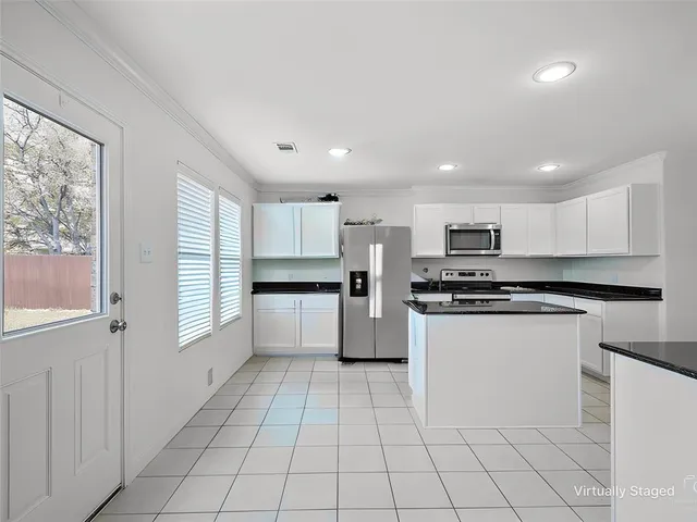 a kitchen with stainless steel appliances a refrigerator sink and cabinets