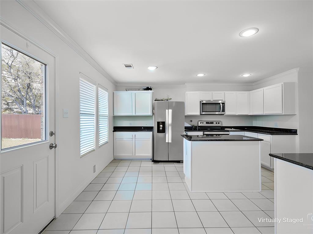 2549 Saddlehorn Drive Little Elm, TX 75068 - Photo 7 of 23 a kitchen with stainless steel appliances a refrigerator sink and cabinets