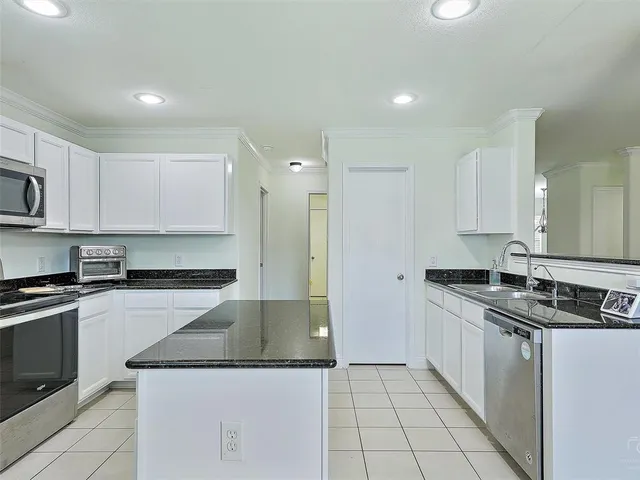a kitchen with stainless steel appliances granite countertop a sink and a stove