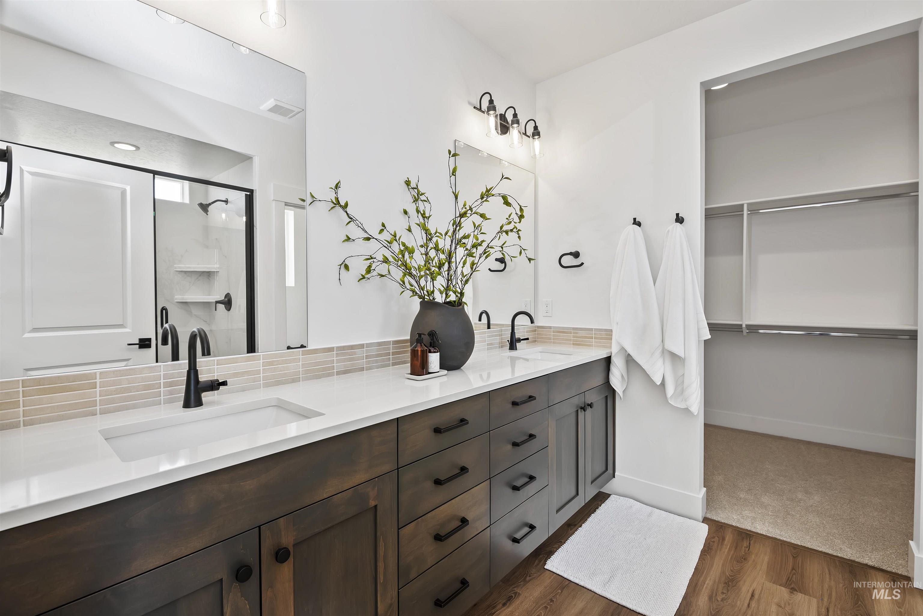 749 South Calhoun Lane Star, ID 83669 - Photo 25 of 34 Full bathroom featuring double vanity, a shower stall, a spacious closet, and dark wood-type flooring