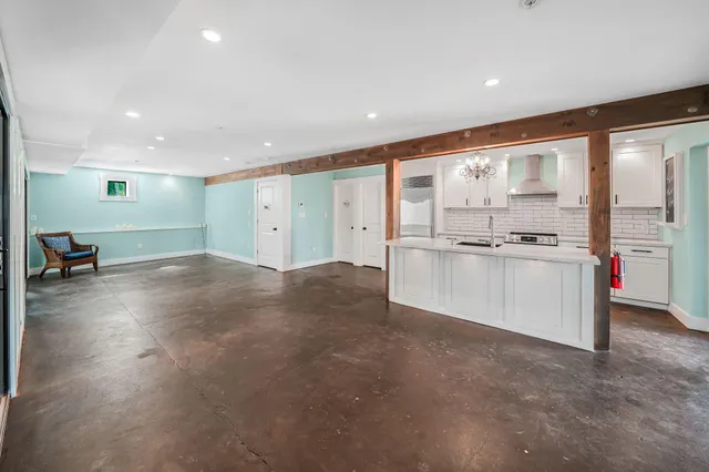 a large kitchen with stainless steel appliances a large counter top and a stove top oven