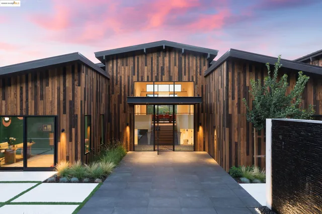 a view of wooden house with a yard and large window