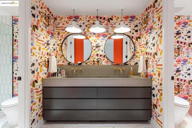 a bathroom with a granite countertop sink a toilet a mirror and shower