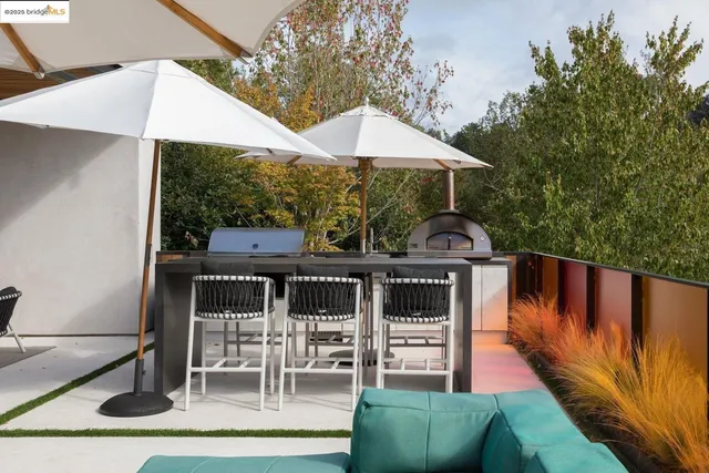 an aerial view of a house with yard and trees in the background