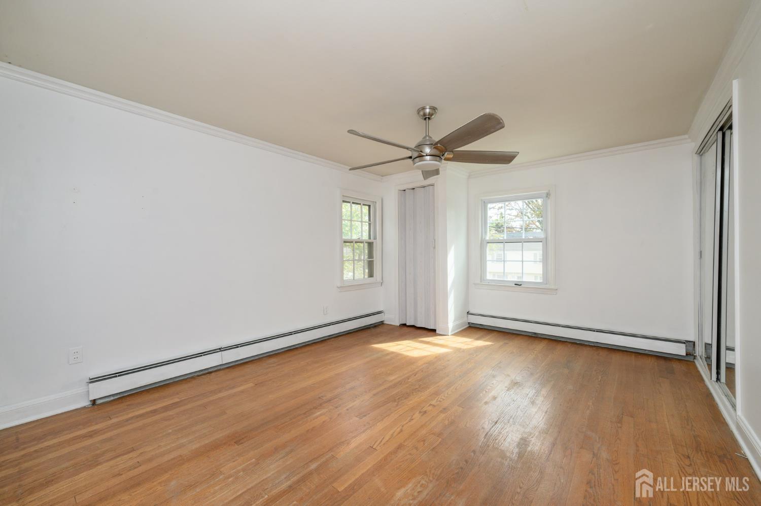 212 Echo Avenue Edison, NJ 08837 - Photo 20 of 42 an empty room with wooden floor window and ceiling fan