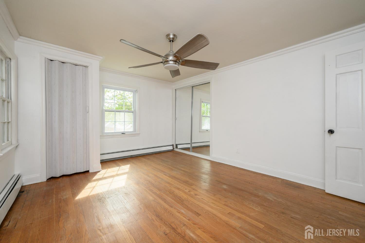212 Echo Avenue Edison, NJ 08837 - Photo 21 of 42 an empty room with wooden floor and windows