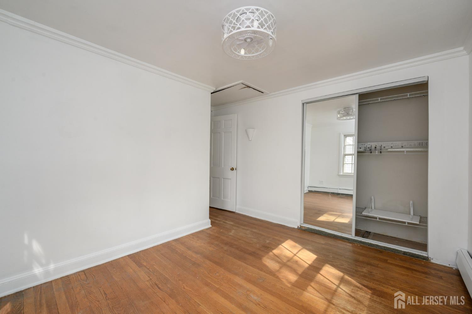 212 Echo Avenue Edison, NJ 08837 - Photo 30 of 42 an empty room with wooden floor cabinet and windows