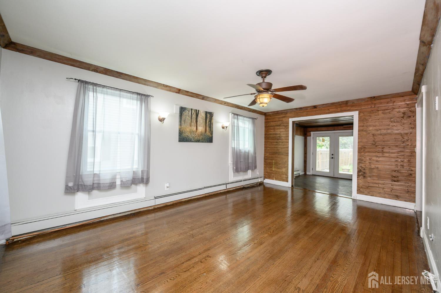 212 Echo Avenue Edison, NJ 08837 - Photo 3 of 42 a view of an empty room with a window and wooden floor