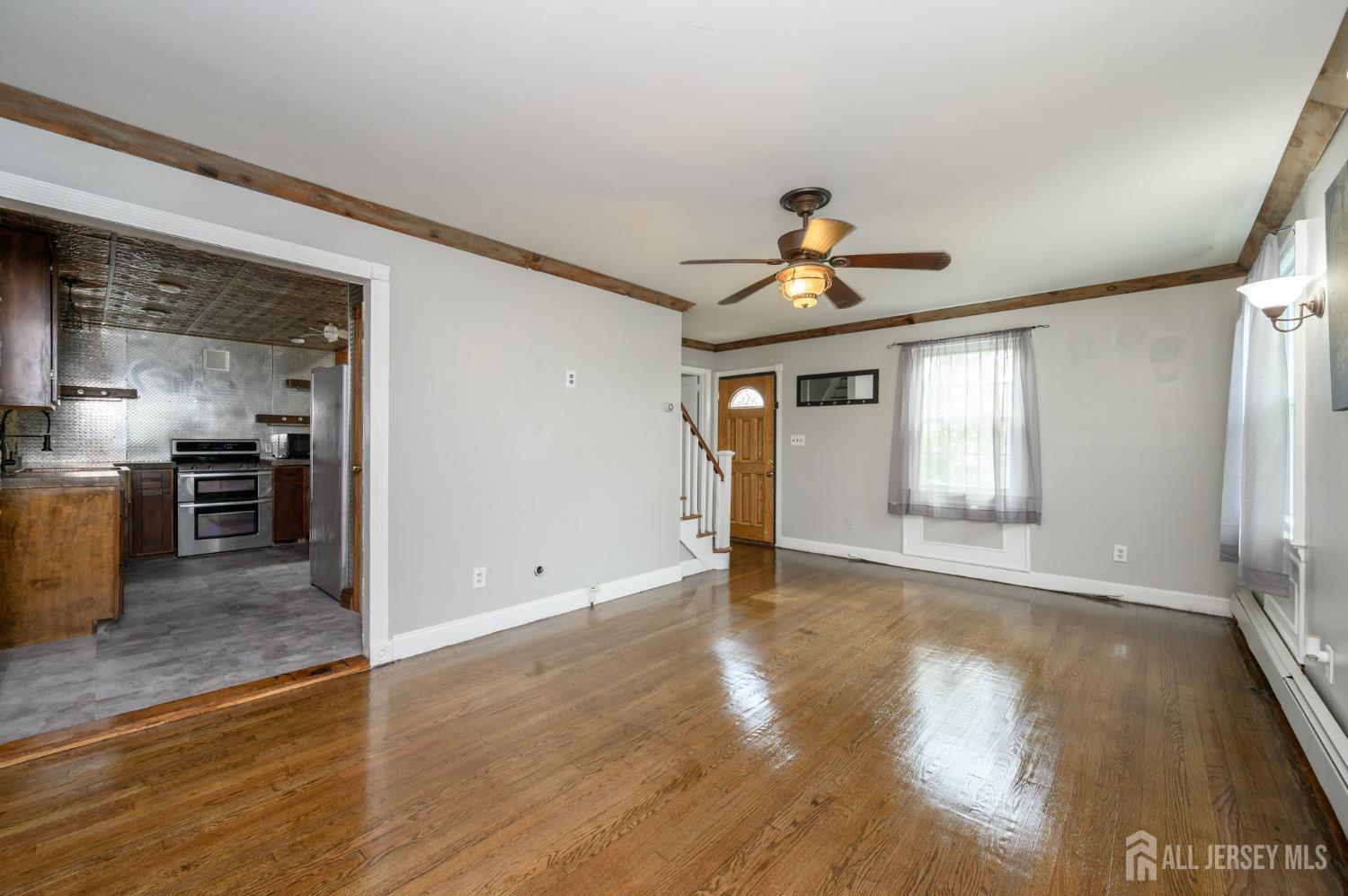212 Echo Avenue Edison, NJ 08837 - Photo 5 of 42 a view of an empty room with window and wooden floor