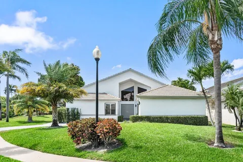 a front view of a house with a garden and trees