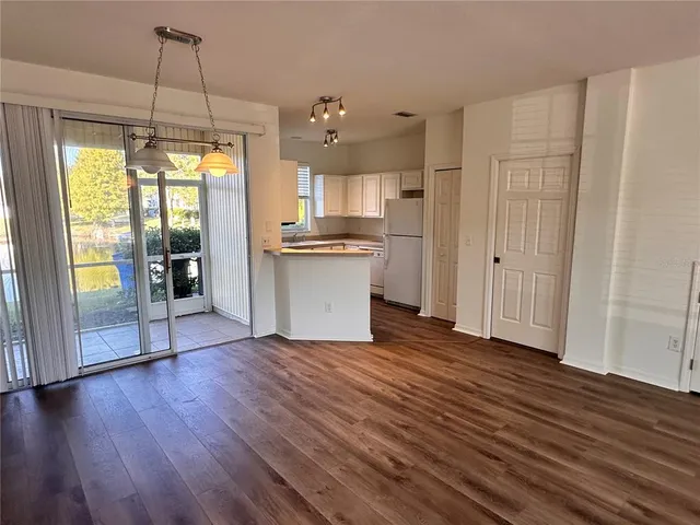 a view of a kitchen with wooden floor and a ceiling fan