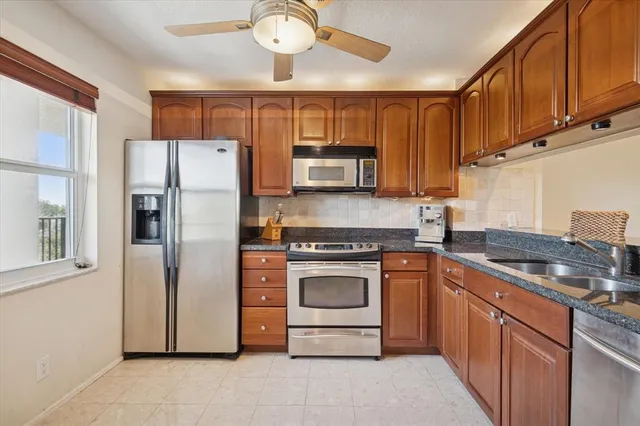 a kitchen with stainless steel appliances granite countertop a refrigerator stove and sink