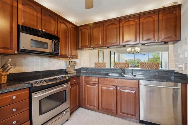a kitchen with granite countertop cabinets stainless steel appliances and a counter space