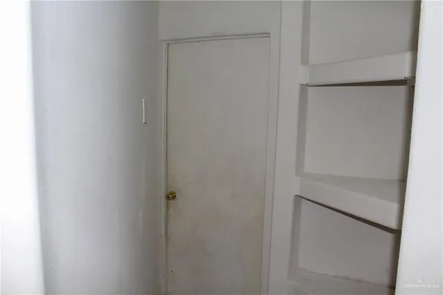 an empty room with windows and mirror