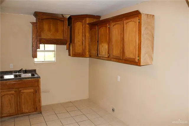 an empty room with windows and cabinet