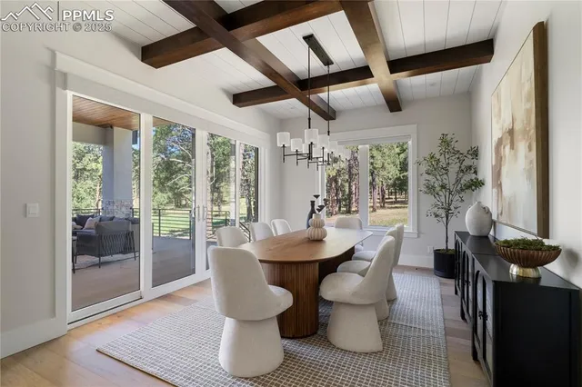 a dining room with furniture wooden floor and a chandelier