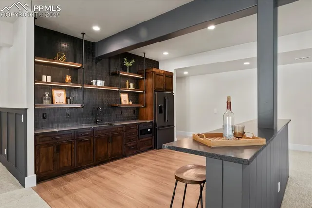 a kitchen with stainless steel appliances granite countertop a sink and a refrigerator