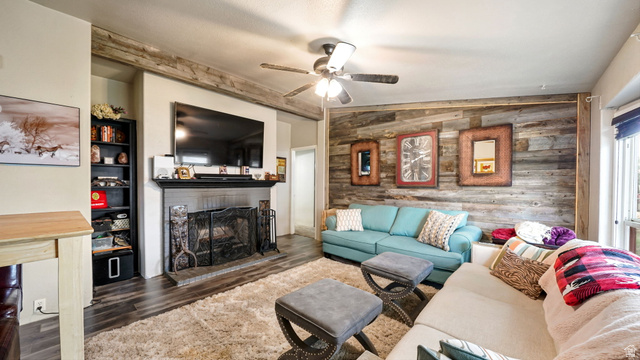 490 South Main Street Kamas, UT 84036 - Photo 5 of 25 Living area featuring a floor-to-ceiling wood plank accent wall and dark wood-finish flooring